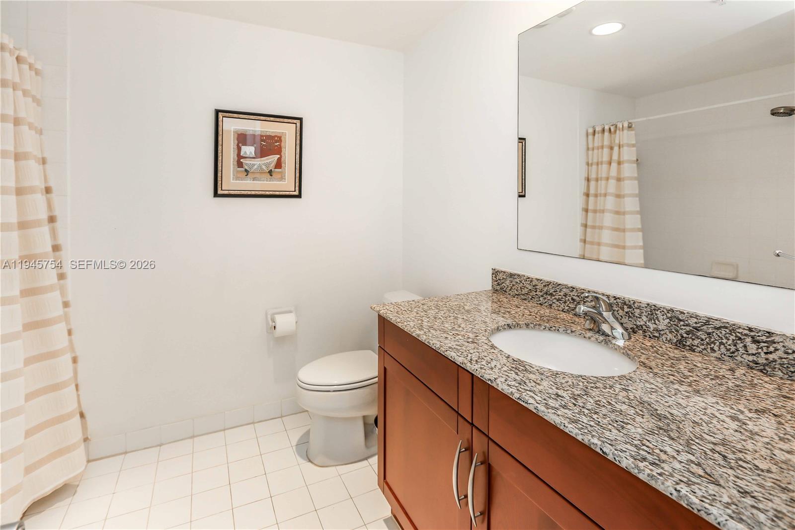 7275 Southwest 89th Street, Unit B416 Miami, FL 33156 - Photo 19 of 32 a bathroom with a granite countertop sink and a mirror