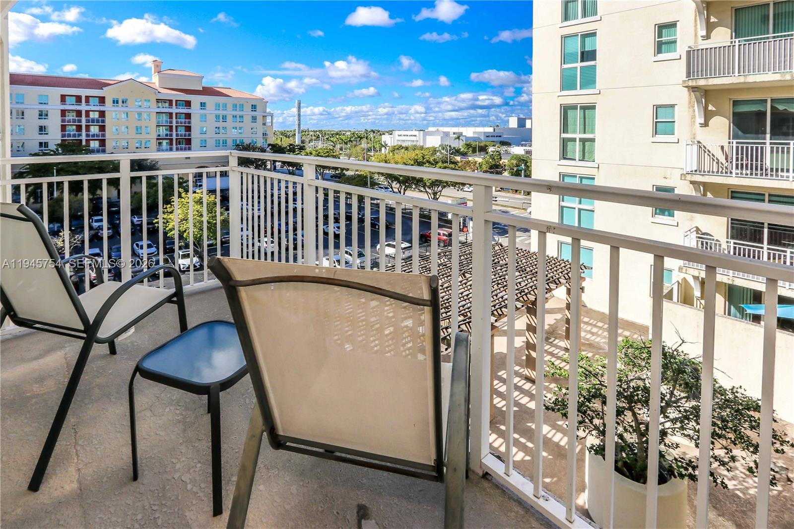 7275 Southwest 89th Street, Unit B416 Miami, FL 33156 - Photo 22 of 32 a view of a balcony with chairs and a table
