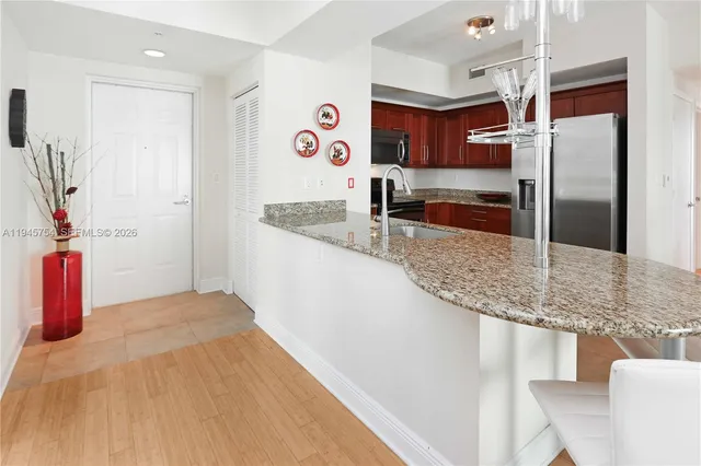 a kitchen with stainless steel appliances granite countertop a sink and a refrigerator