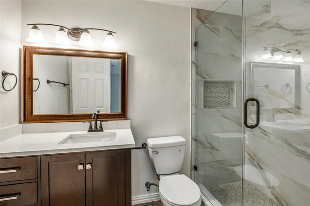 a bathroom with a toilet sink shower and mirror