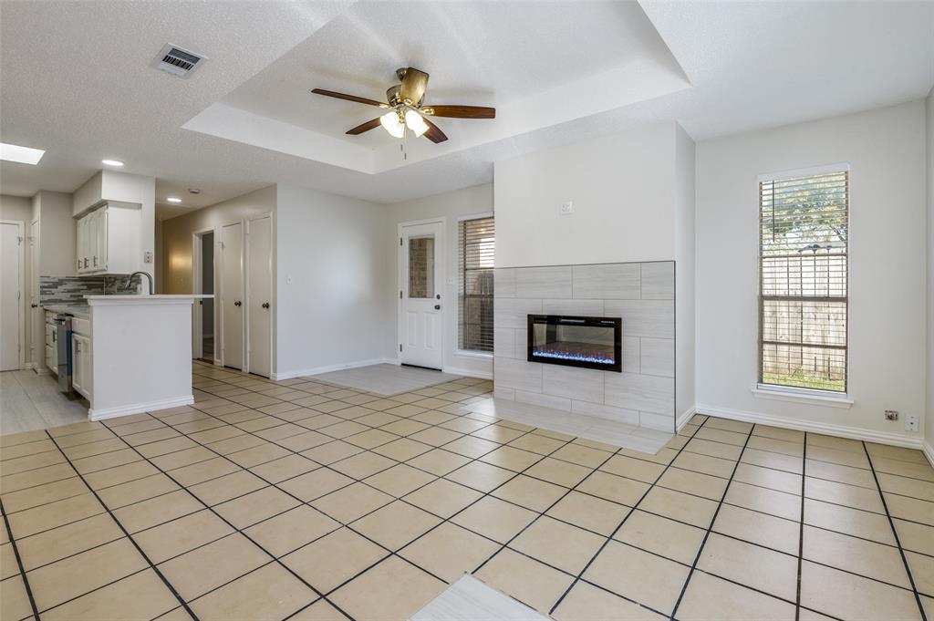 8940 Thompson Circle Frisco, TX 75033 - Photo 4 of 15 a view of a livingroom with a fireplace a ceiling fan and windows