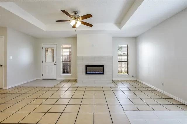 an empty room with windows and fireplace