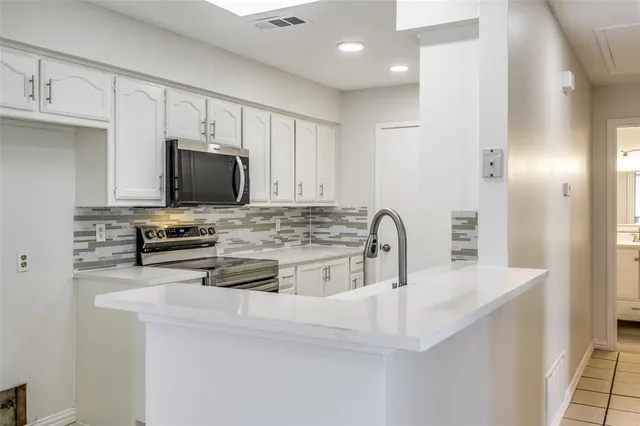 a kitchen with stainless steel appliances a stove a sink a microwave and refrigerator