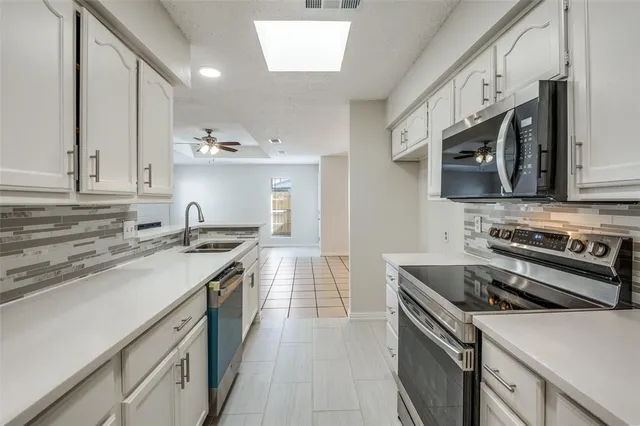 a kitchen with stainless steel appliances a sink stove and cabinets