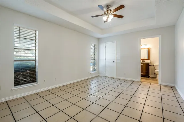 a view of an empty room and window with a chandelier fan