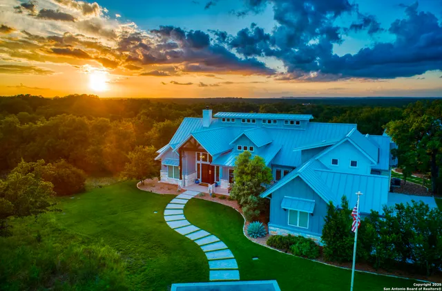 a view of a big house with a big yard and potted plants