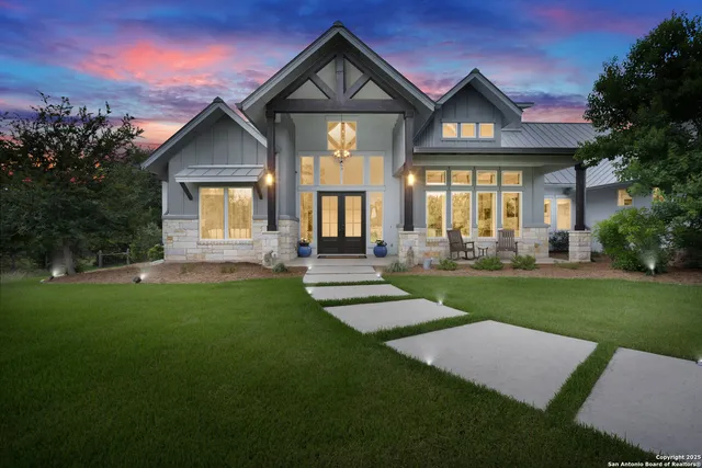 a front view of a house with a yard and trees