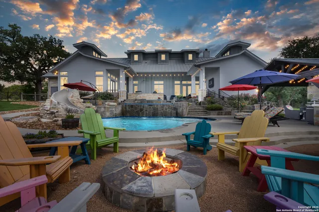 a view of a house with backyard water fountain and sitting area