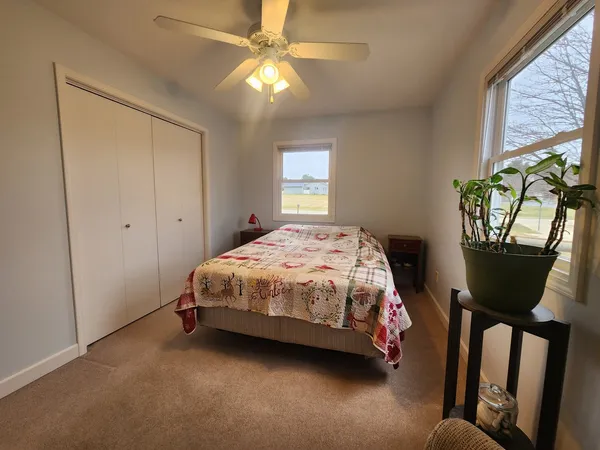 a bedroom with a bed a window and dresser