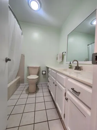 a spacious bathroom with a double vanity sink toilet and a tub