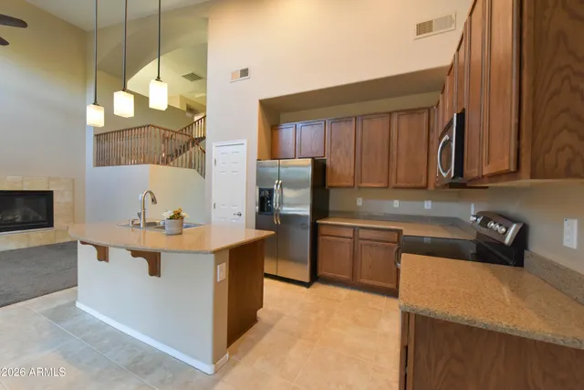 a kitchen with stainless steel appliances granite countertop a sink a stove and a wooden floors