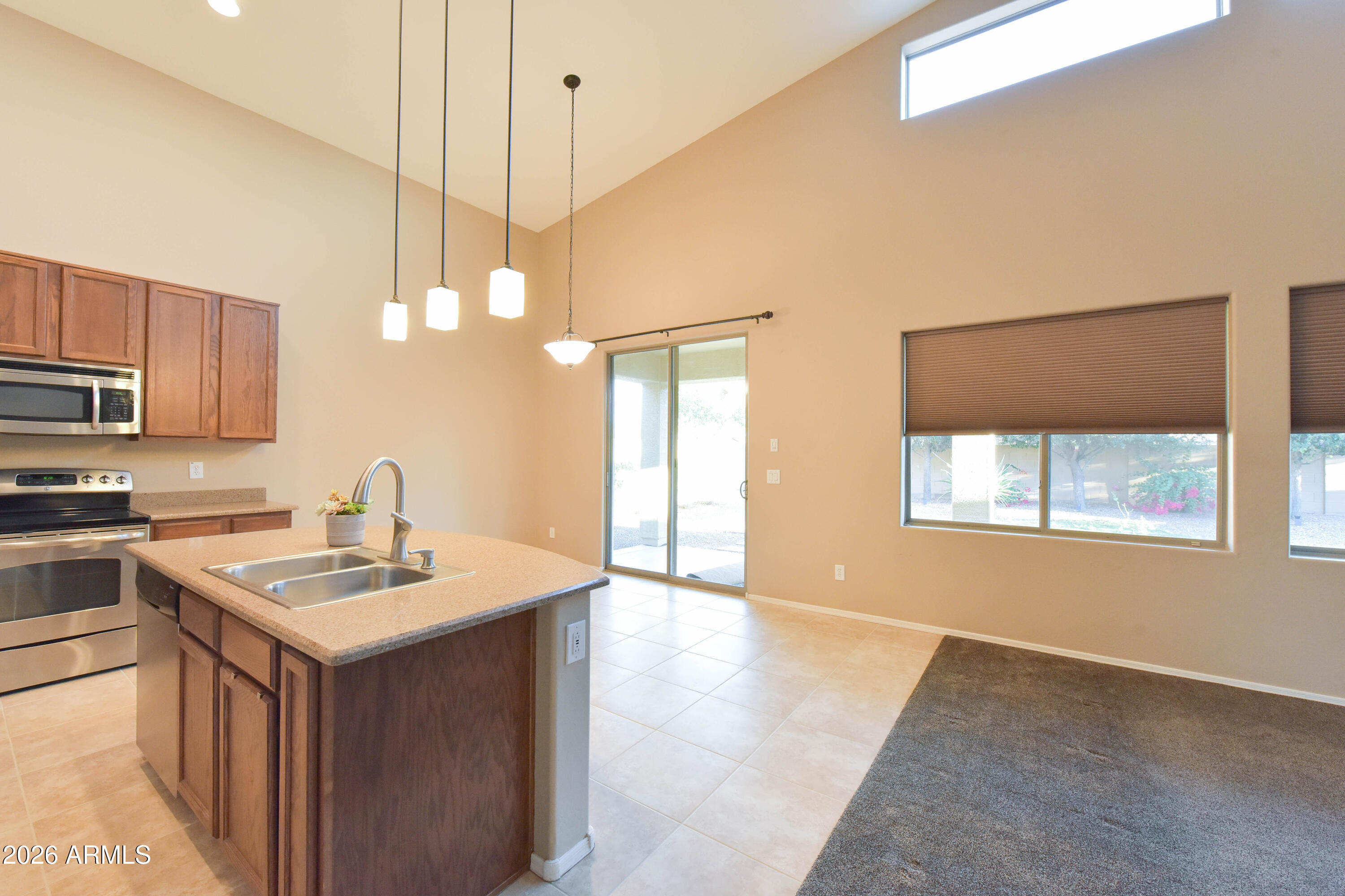 2546 East San Rafael Trail Casa Grande, AZ 85194 - Photo 13 of 41 a kitchen with a sink a stove a microwave a center island and cabinets