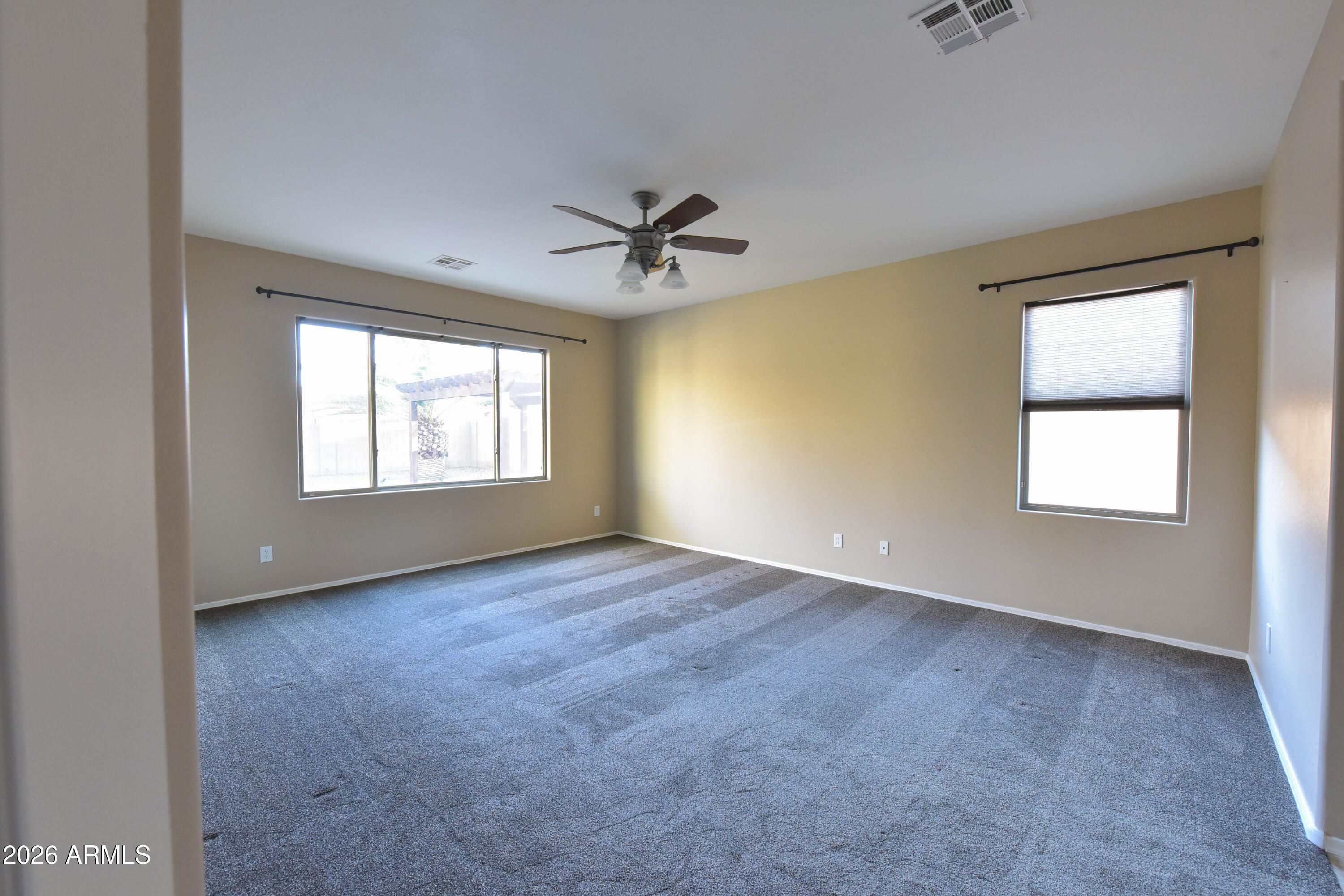 2546 East San Rafael Trail Casa Grande, AZ 85194 - Photo 18 of 41 an empty room with windows and chandelier fan