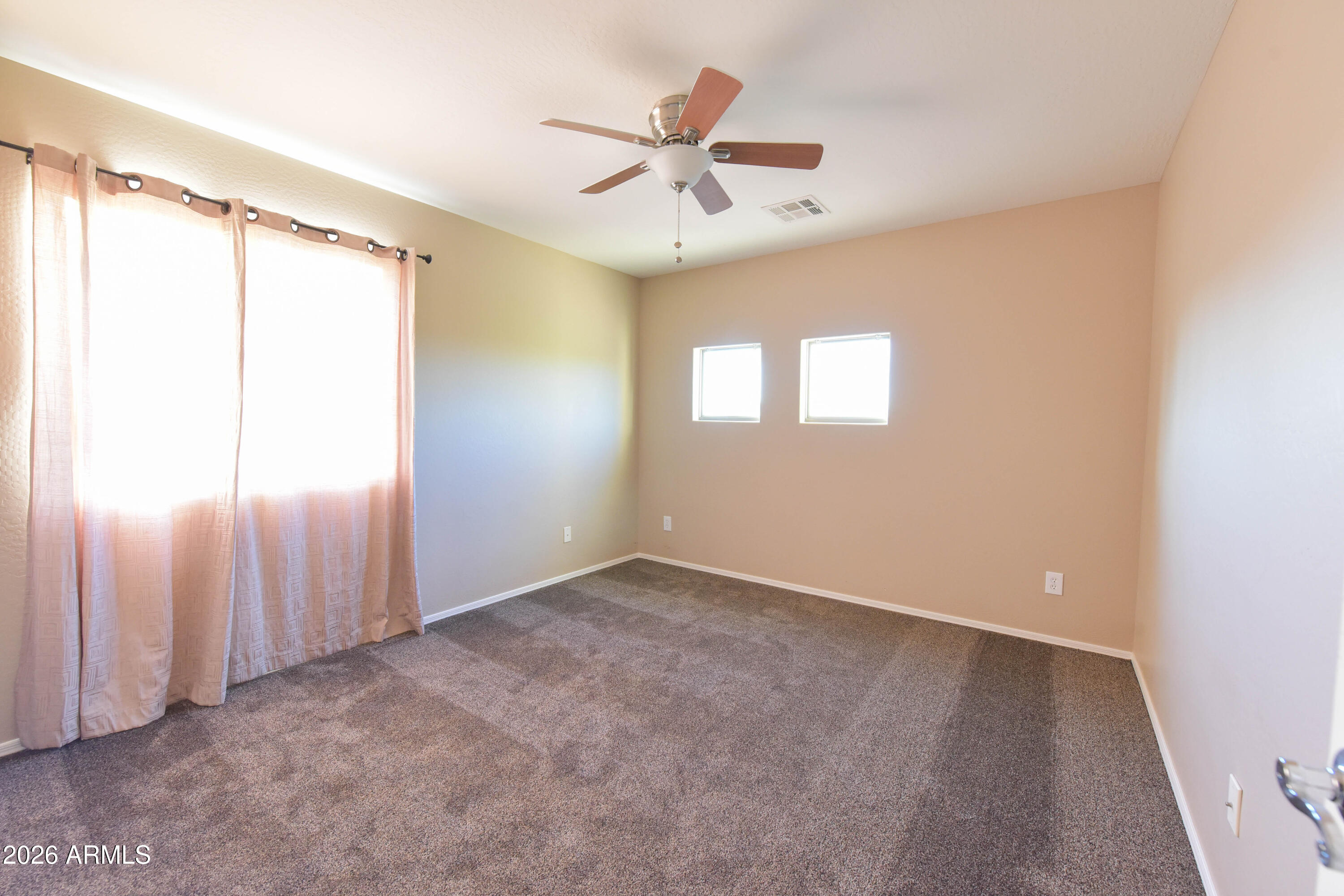 2546 East San Rafael Trail Casa Grande, AZ 85194 - Photo 31 of 41 an empty room with windows and fan