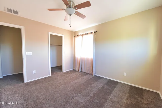 an empty room with a ceiling fan and a window