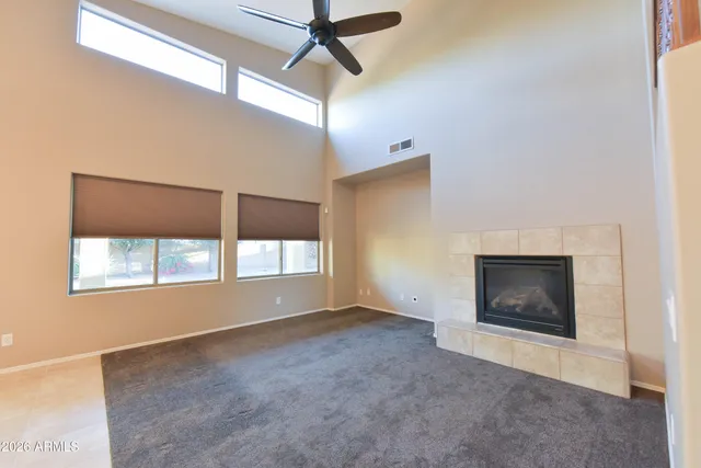 a view of an empty room with a window and fireplace