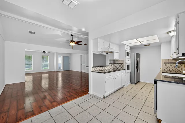 a kitchen with stainless steel appliances granite countertop a stove a sink and a refrigerator