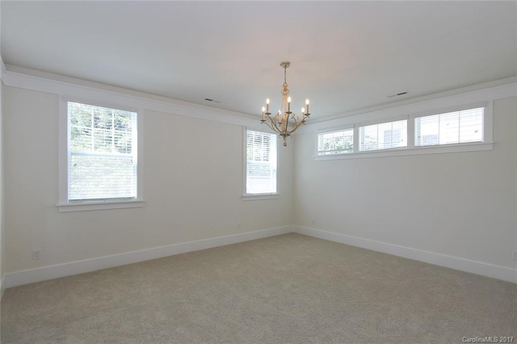 908 Millbrook Road, Unit B Charlotte, NC 28211 - Photo 13 of 23 en empty room with windows and chandelier