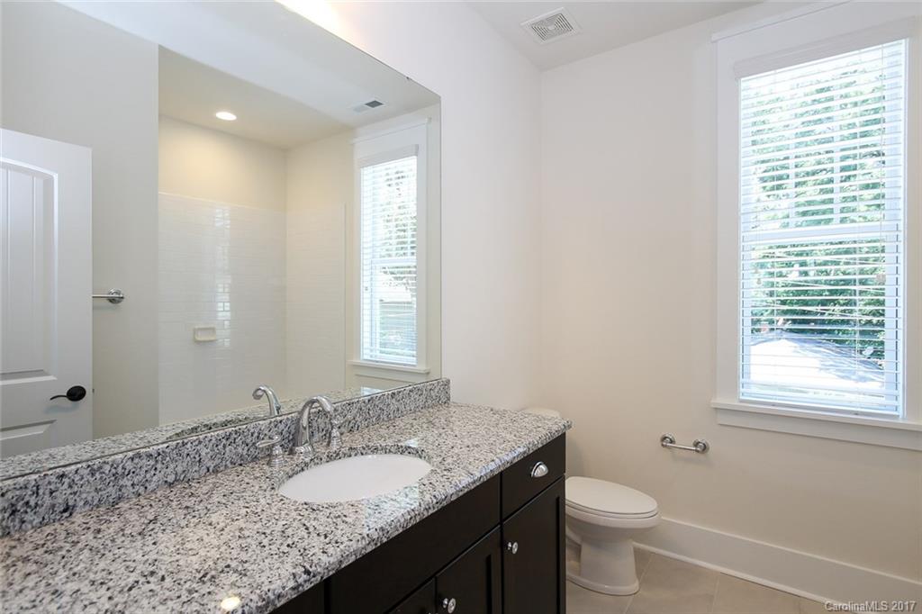 908 Millbrook Road, Unit B Charlotte, NC 28211 - Photo 16 of 23 a bathroom with a granite countertop sink toilet and mirror