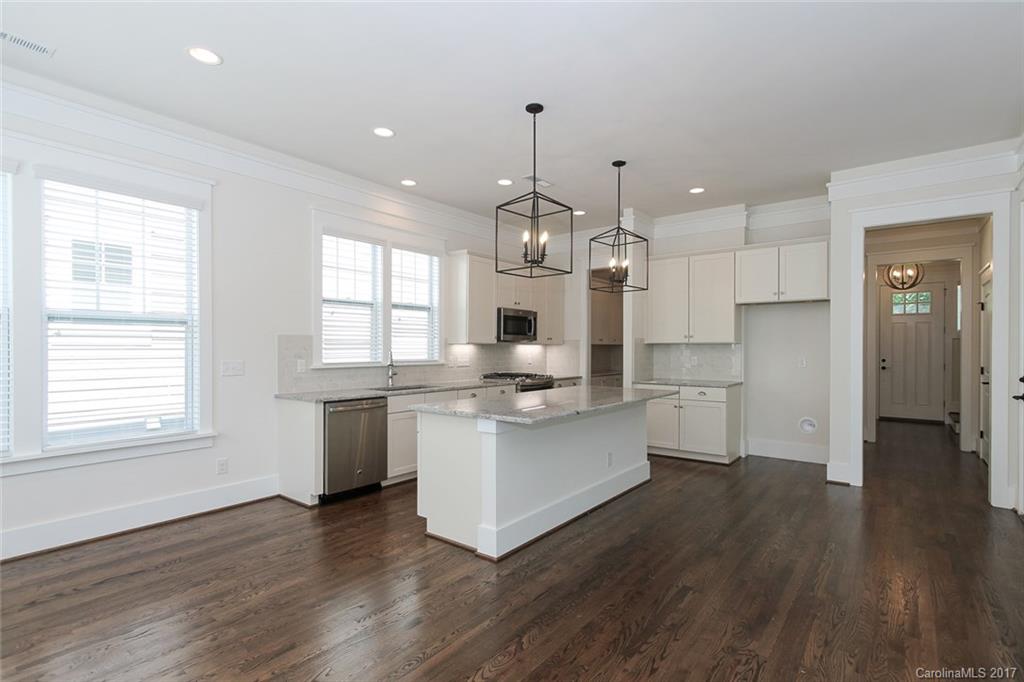 908 Millbrook Road, Unit B Charlotte, NC 28211 - Photo 5 of 23 a kitchen with stainless steel appliances granite countertop a refrigerator a sink dishwasher a stove and white countertops with wooden floor