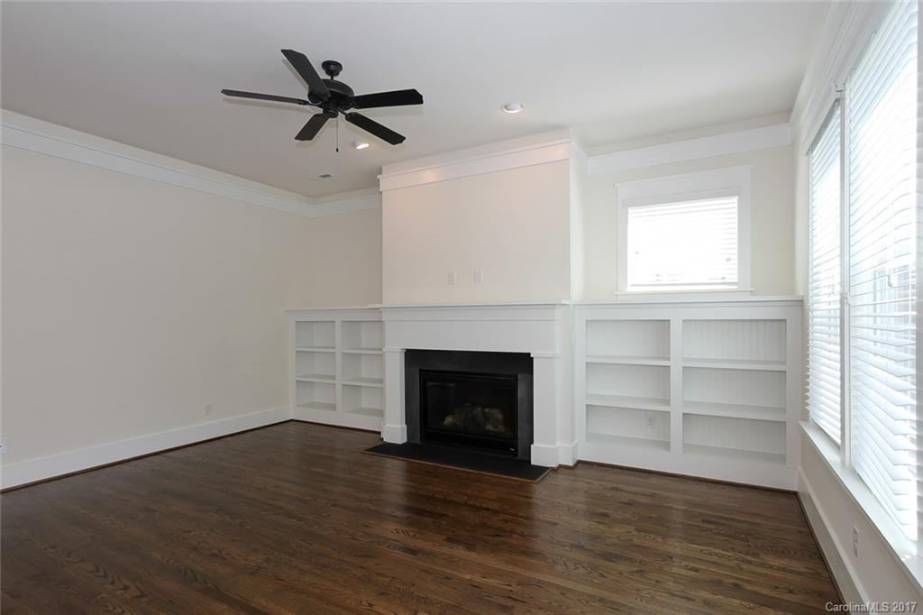 908 Millbrook Road, Unit B Charlotte, NC 28211 - Photo 9 of 23 an empty room with wooden floor a fireplace and windows