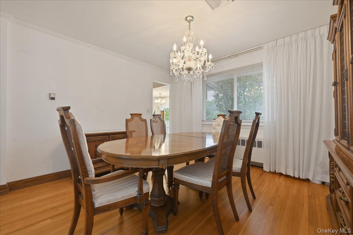 17 Avon Road Farmingdale, NY 11735 - Photo 8 of 46 a view of a dining room with furniture a chandelier and wooden floor