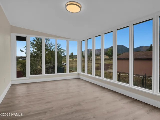 an empty room with windows and fan
