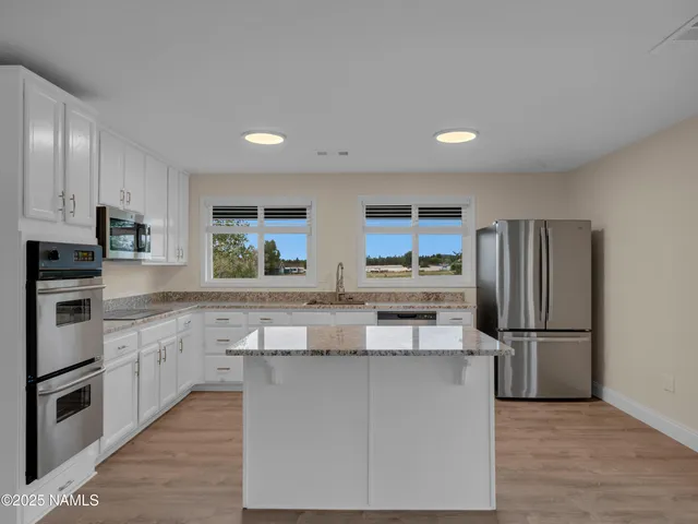 a kitchen with stainless steel appliances granite countertop a stove a sink and a refrigerator