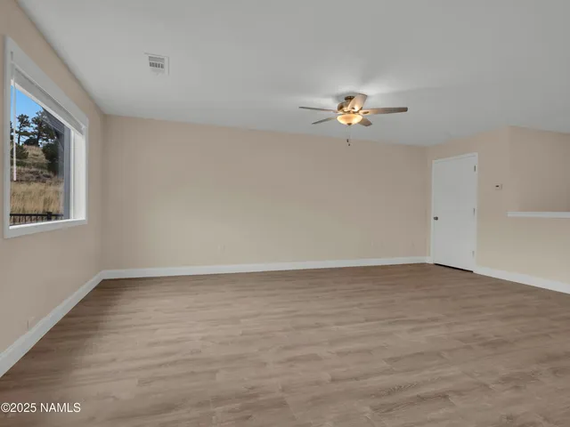 a view of a livingroom with a ceiling fan and window