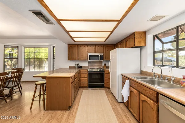 a kitchen with sink a microwave and cabinets