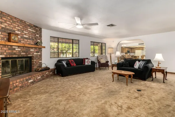 a living room with furniture a flat screen tv and a large window