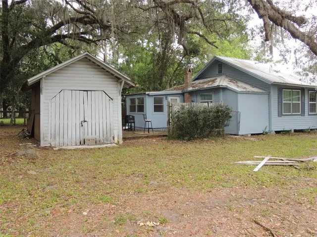 a view of a house with backyard and trees