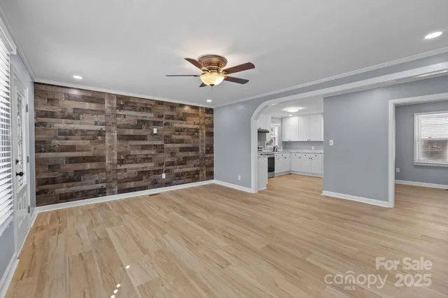 a view of empty room with wooden floor and a ceiling fan