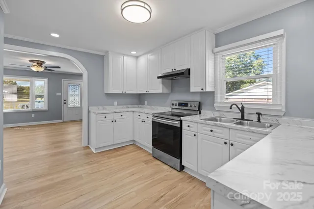 a kitchen with stainless steel appliances granite countertop a sink stove and refrigerator