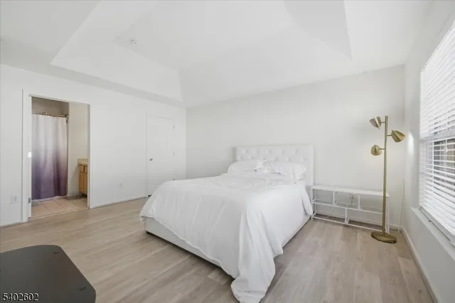 a spacious bedroom with a bed and a wooden floor