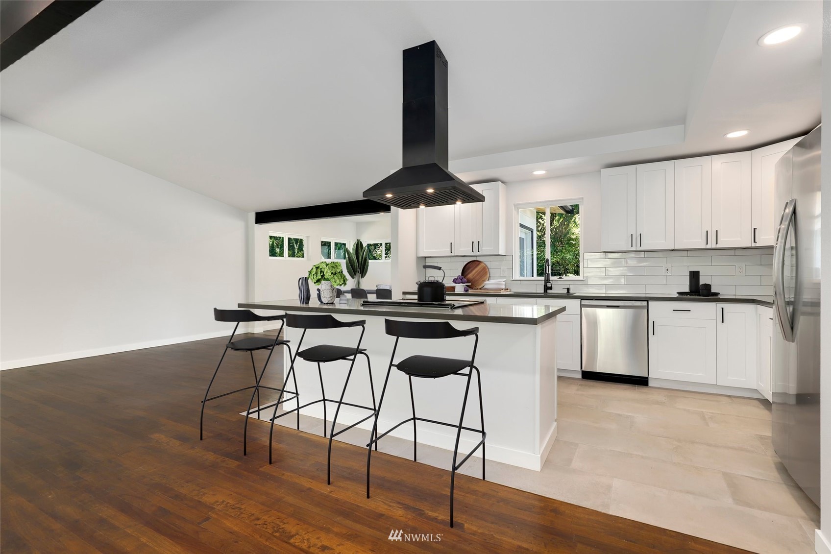 23314 25th Drive Southeast Bothell, WA 98021 - Photo 13 of 40 a kitchen with stainless steel appliances a dining table chairs and a wooden floor
