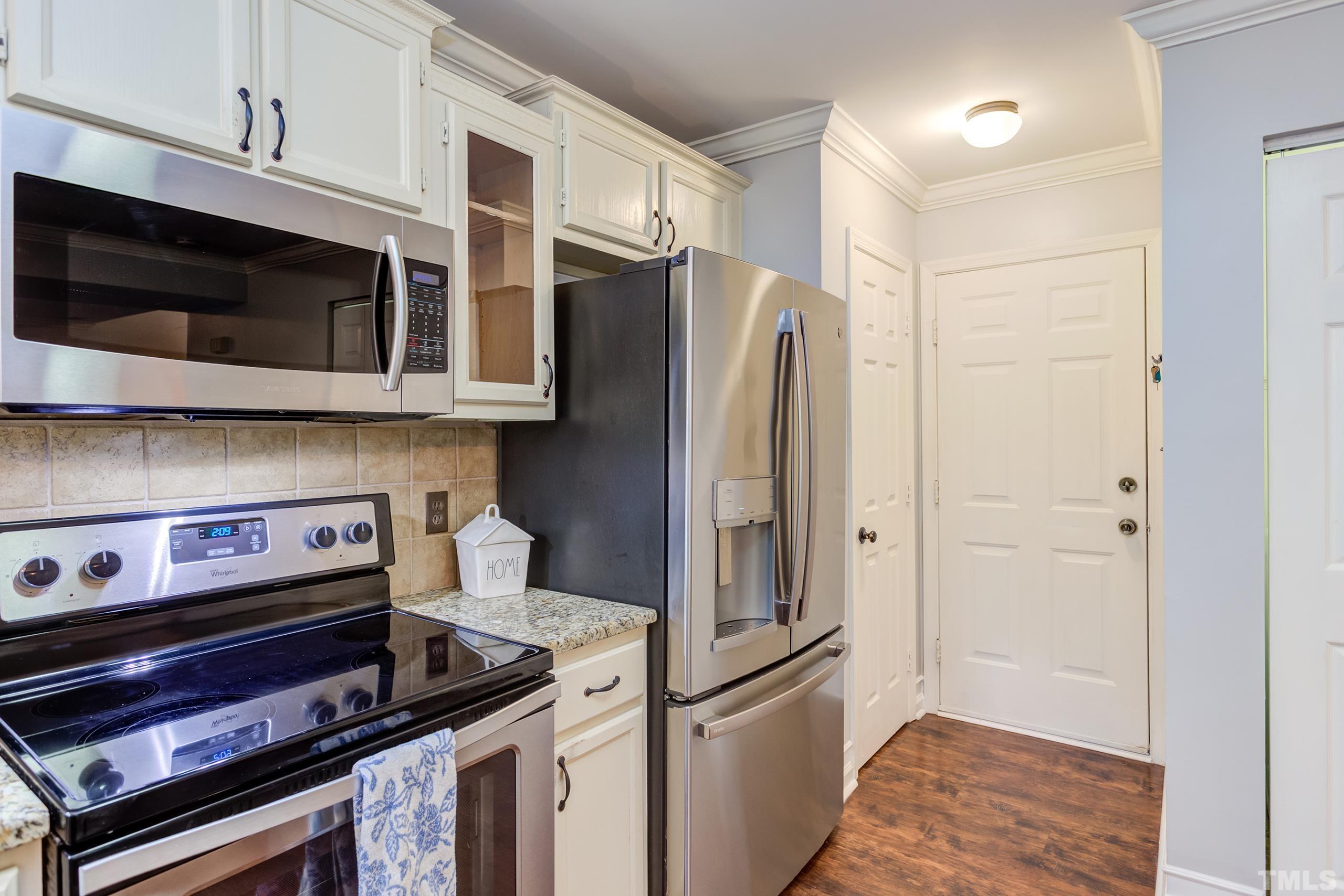 206 Eagle Tavern Drive Garner, NC 27529 - Photo 13 of 41 a kitchen with stainless steel appliances a refrigerator and a stove top oven