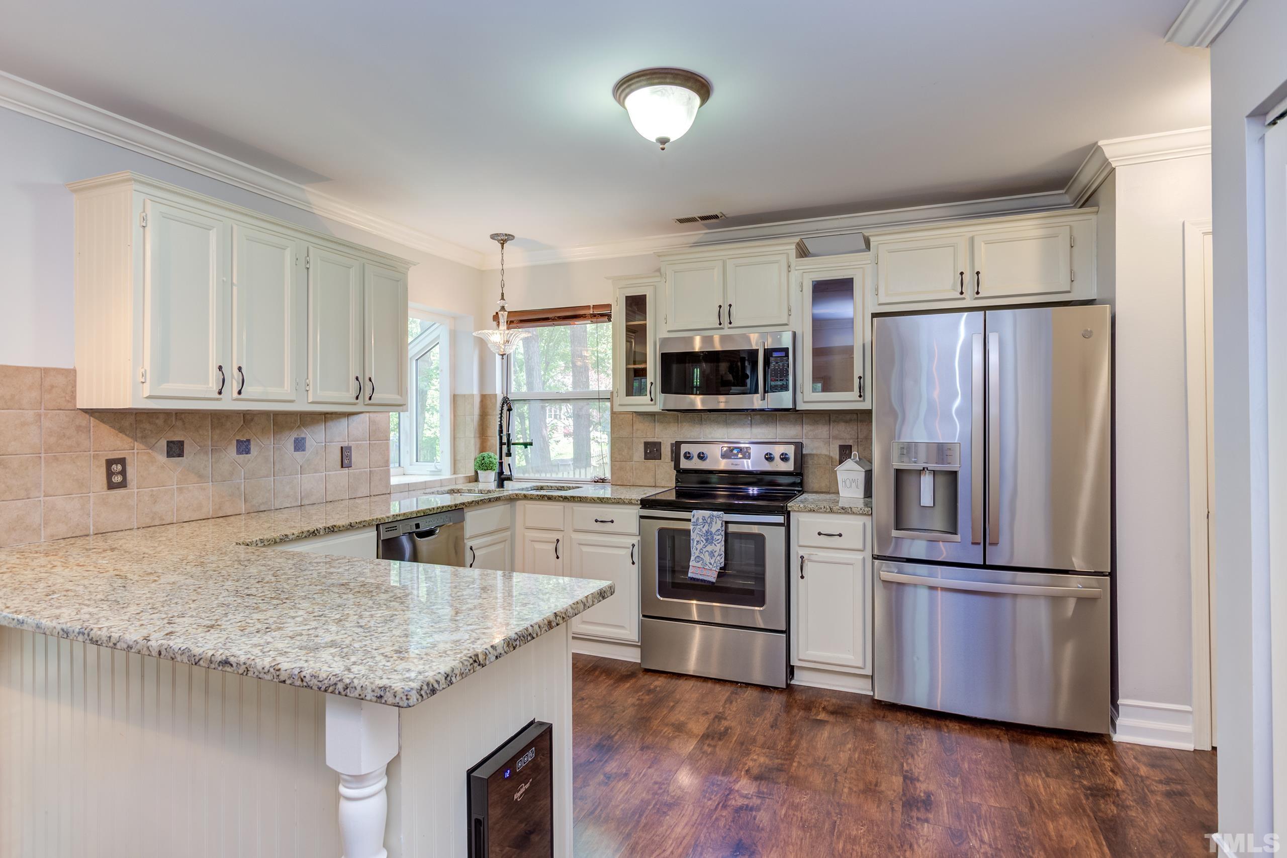 206 Eagle Tavern Drive Garner, NC 27529 - Photo 8 of 41 a kitchen with granite countertop a refrigerator a sink a stove a microwave and wooden floor