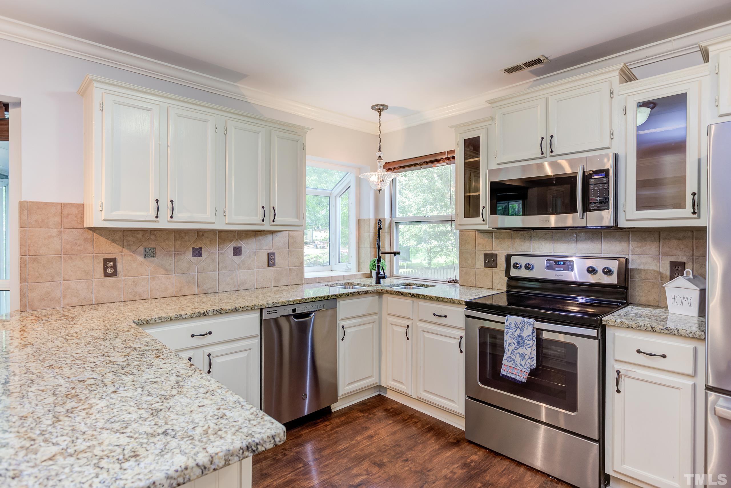 206 Eagle Tavern Drive Garner, NC 27529 - Photo 9 of 41 a kitchen with stainless steel appliances granite countertop a stove top oven a sink and a microwave