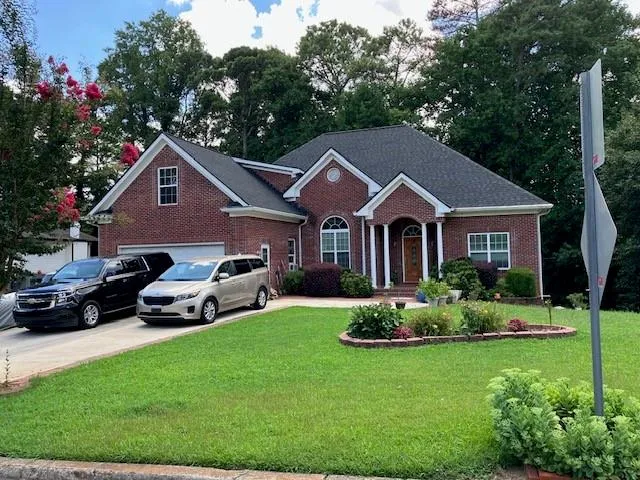 a front view of a house with a garden and plants