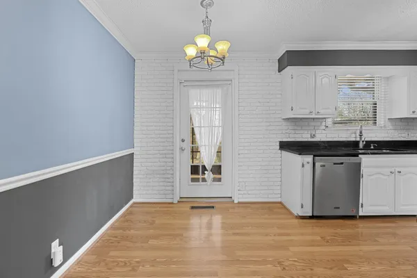 a kitchen with granite countertop white cabinets and appliances