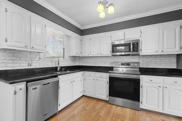 a kitchen with granite countertop a sink and a stove top oven