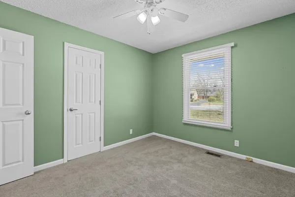 an empty room with closet and fan