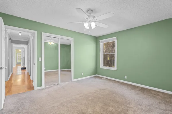 an empty room with a ceiling fan and a window
