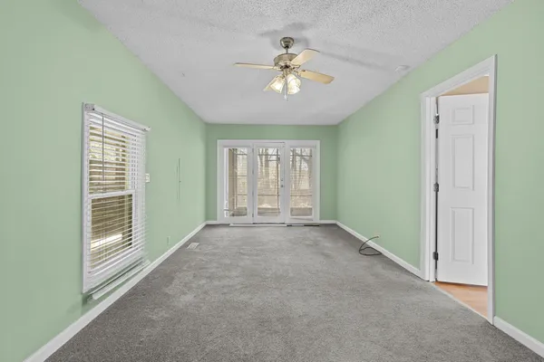 a view of an empty room with wooden floor and windows