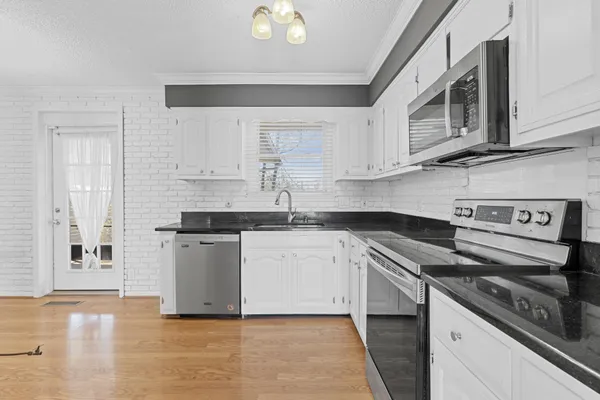 a kitchen with granite countertop white cabinets and white appliances
