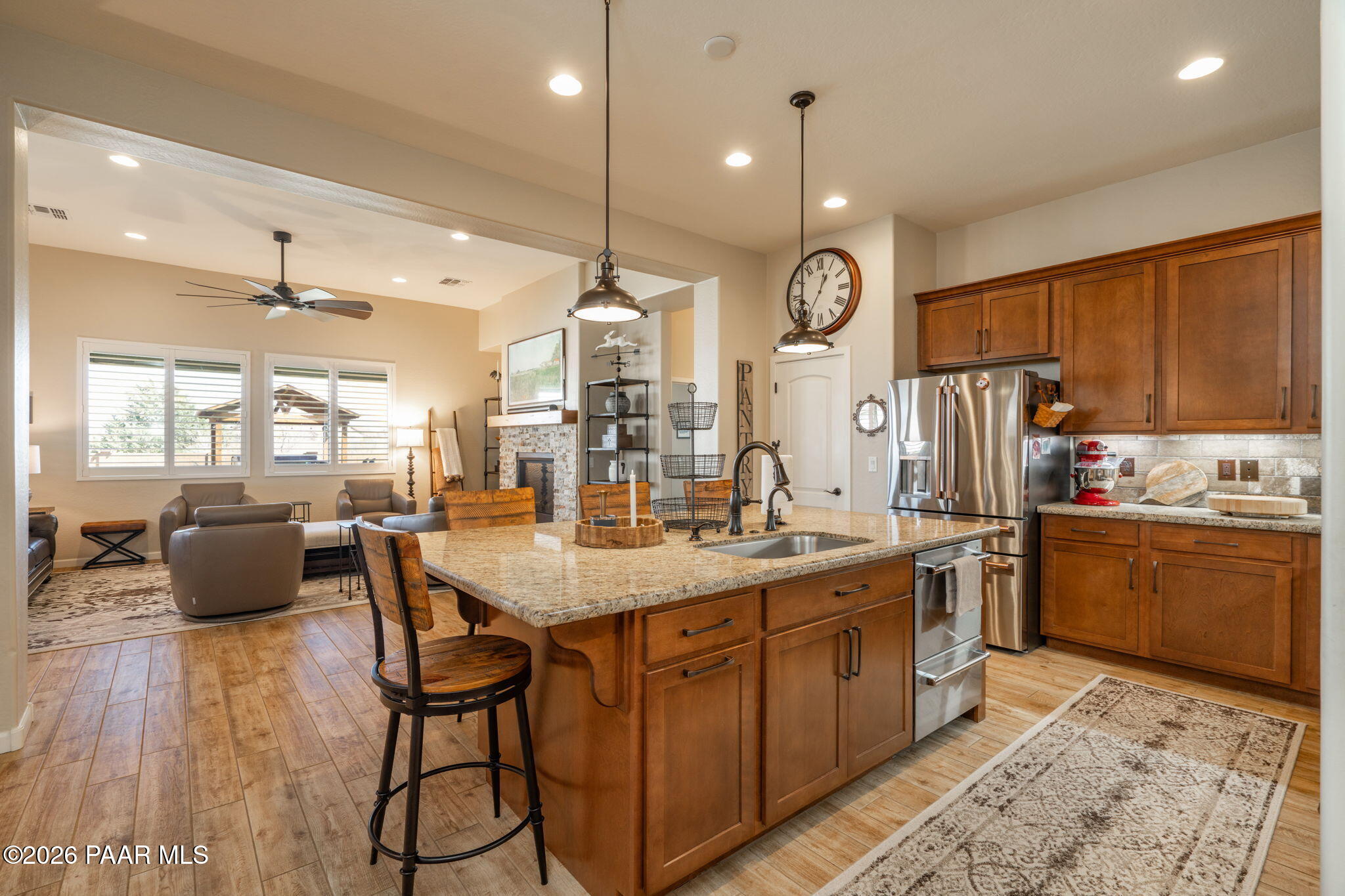 707 Lunar View Way Chino Valley, AZ 86323 - Photo 22 of 89 a kitchen with stainless steel appliances kitchen island granite countertop a stove a sink dishwasher and white cabinets with wooden floor