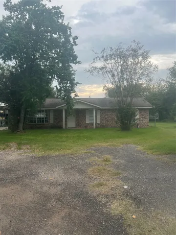 a view of a house with a yard and a tree