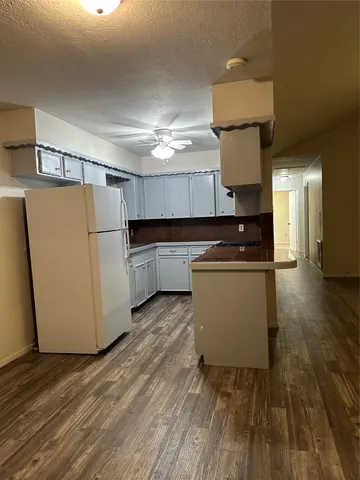 a kitchen with a refrigerator a stove a microwave and wooden floor
