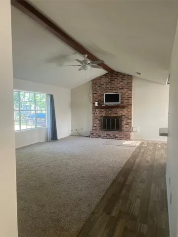 a view of empty room with fireplace and windows
